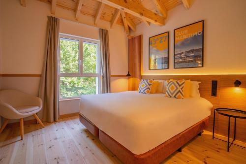 a bedroom with a large white bed and a window at Sercotel El Balcón de la Bahía Suites in Santander