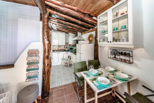 cocina y comedor con mesa y sillas en La Casita del Árbol Blanco en Bubión