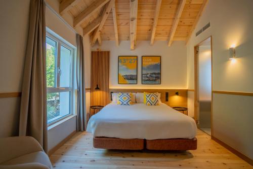 1 dormitorio con cama y ventana grande en Sercotel El Balcón de la Bahía Suites, en Santander