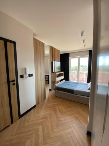 1 dormitorio con 1 cama y nevera en una habitación en Apartament Nowe Zatorze 92, en Olsztyn