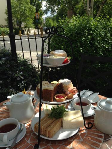 a plate of food on a table with cups of tea at The Colonnade in London