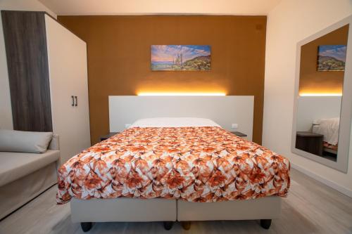 a bedroom with a bed with a orange blanket at Tenuta da Rino - Agriturismo Barco Menti in Vicenza
