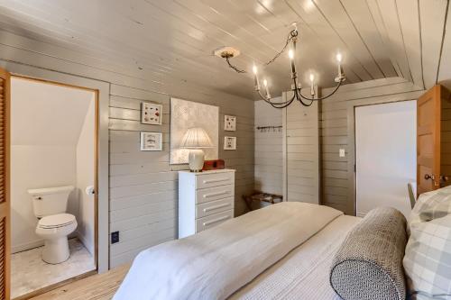 1 dormitorio con cama, aseo y lámpara de araña en A-Lodge Lyons en Lyons
