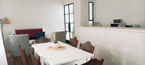 a dining room with a white table and chairs at CASA ATELIER in Tilcara