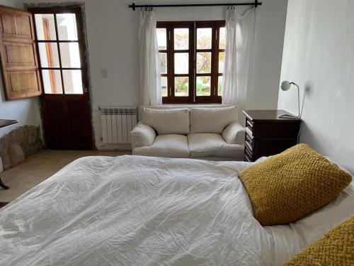 a bedroom with a large bed and a couch at CASA ATELIER in Tilcara