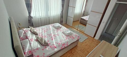 ein Schlafzimmer mit einem Bett mit Schuhen drauf in der Unterkunft 2H Apartment in Sarajevo
