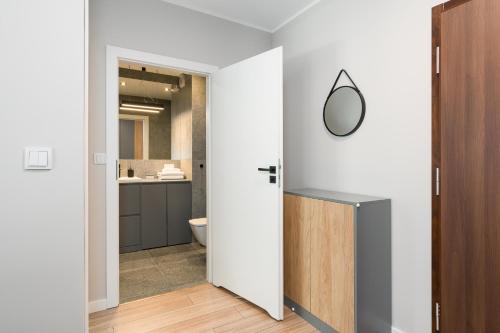 a bathroom with a toilet and a mirror on the wall at Bookowska Apartments in Poznań