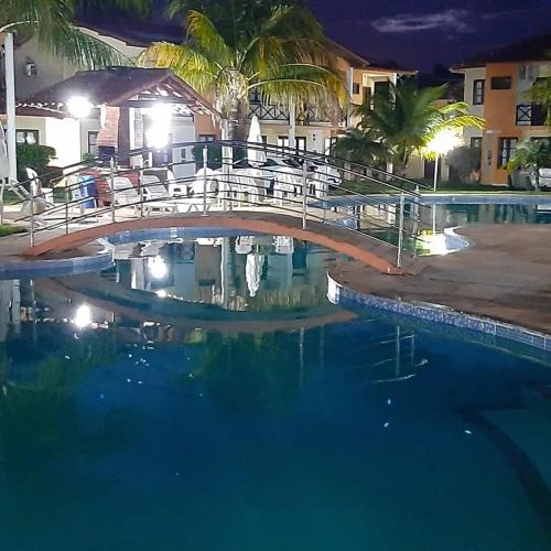 a bridge over a swimming pool at night at Casa Moradas de Israel in Porto Seguro