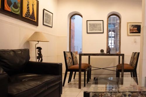 Giuseppe Suites Hotel في أسونسيون: غرفة معيشة مع أريكة وطاولة وكراسي