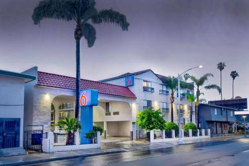 a hotel on the side of a street with a palm tree at Motel 6-Inglewood, CA in Inglewood
