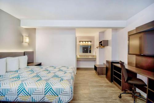 イングルウッドにあるMotel 6-Inglewood, CAのベッドとデスクが備わるホテルルームです。