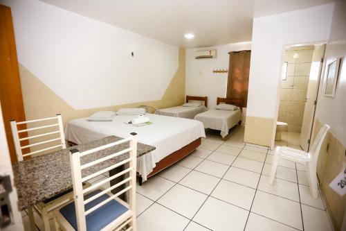 a hotel room with two beds and a shower at Hotel Barão Palace in Teresina