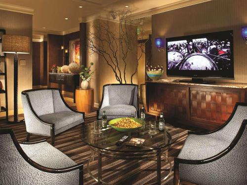 a living room with a table and chairs and a television at Fairmont Dallas in Dallas