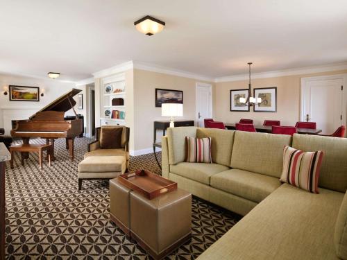 a living room filled with furniture and a piano at Fairmont Le Manoir Richelieu in La Malbaie