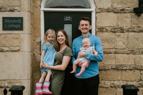 Eine Familie, die für ein Bild vor einem Fenster posiert in der Unterkunft Bluebell cottage Branston Lincoln in Branston