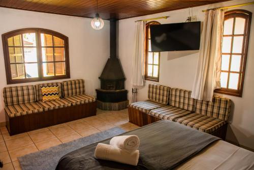 a bedroom with a bed and a fireplace and a tv at Pousada Tapera in Penedo
