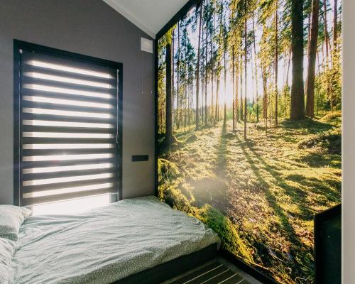 ein Schlafzimmer mit einem Wandbild eines Waldes in der Unterkunft ŚwiętySpokój Puszcza in Białowieża