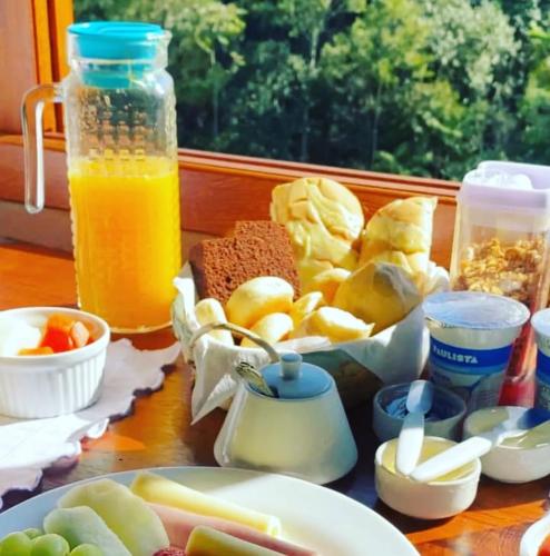 a table topped with a plate of food and orange juice at Pousada Chales Joao de Barro in Visconde De Maua
