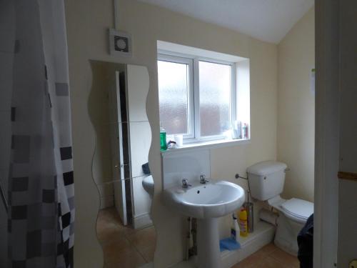 a bathroom with a sink and a toilet and a window at Station House in Shirebrook