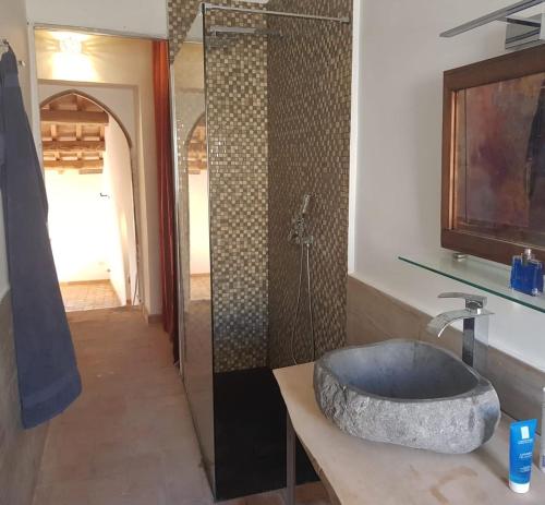 W łazience znajduje się kamienna umywalka i prysznic. w obiekcie Dimora Turistica de' Piazza w mieście Roccalvecce