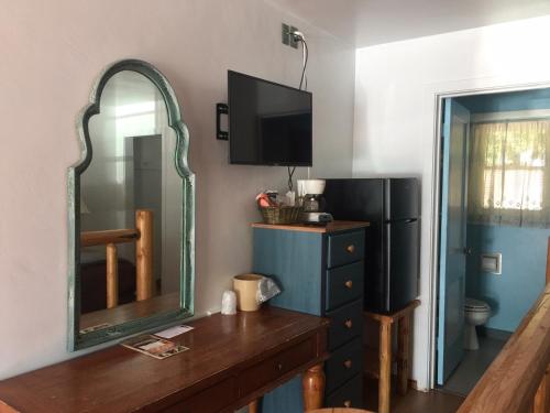 a room with a mirror and a dresser and a refrigerator at Dunsmuir Lodge in Dunsmuir