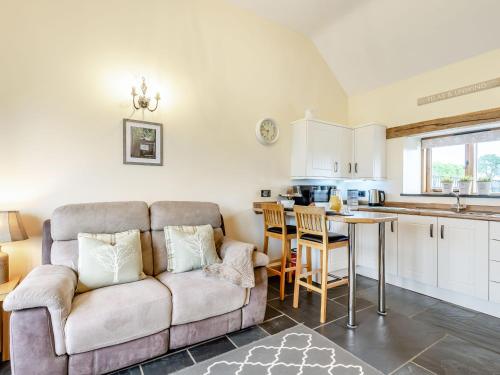 a living room with a couch and a kitchen at The Granary in Llanfair Caereinion