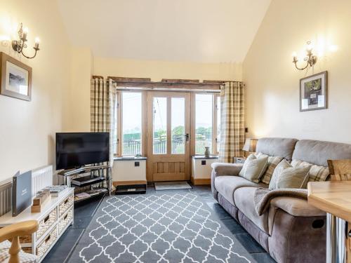 a living room with a couch and a tv at The Granary in Llanfair Caereinion
