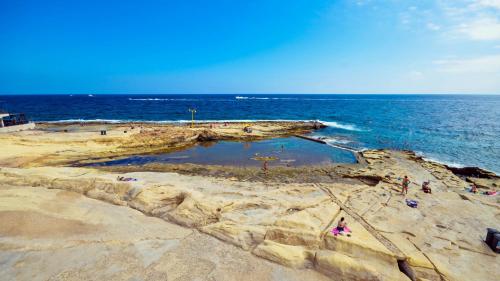 a group of people on a beach near the ocean at Sliema 248 Boutique Studios in Sliema