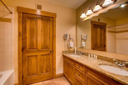 a bathroom with two sinks and a large mirror at Beautiful 3 Bedroom Mountain Condo In River Run Village With Hot Tub Access And Walking Distance To The Gondola in Keystone