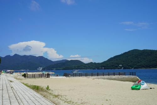 a beach with a boat sitting on the sand at SETOUCHI SUP RESORT - Ao - in Shodoshima