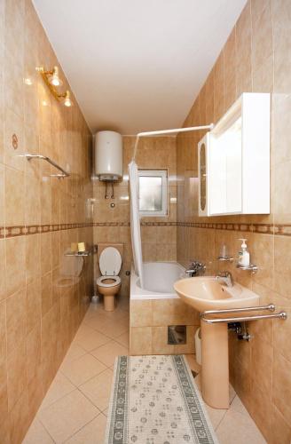 a bathroom with a sink and a toilet and a tub at Apartments with parking space Kampor, Rab - 4972 in Kampor