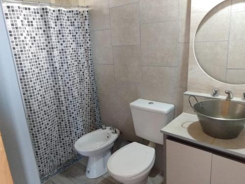 a bathroom with a toilet and a sink and a mirror at Balcón de la montaña in Santa Rosa de Calamuchita