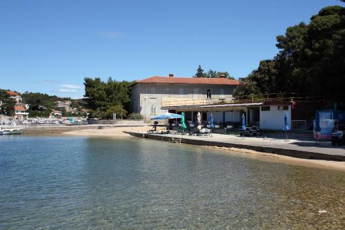 a building on the shore of a body of water at Apartments with a parking space Palit, Rab - 4983 in Rab
