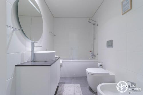 a white bathroom with a sink and a mirror at Home Azores - Coliseu Residences in Ponta Delgada