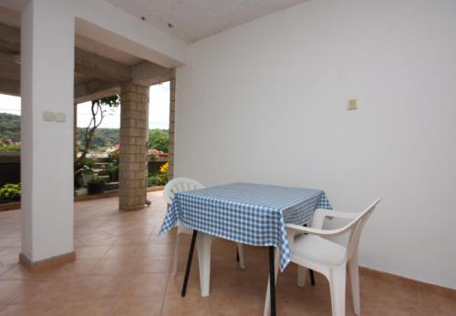 un tavolo e sedie blu e bianco sul balcone di Apartments with parking space Kampor, Rab - 4984 a Rab