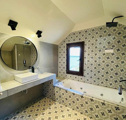 y baño con bañera, lavabo y espejo. en Hostería Nórdico Lake by Nordic en San Carlos de Bariloche