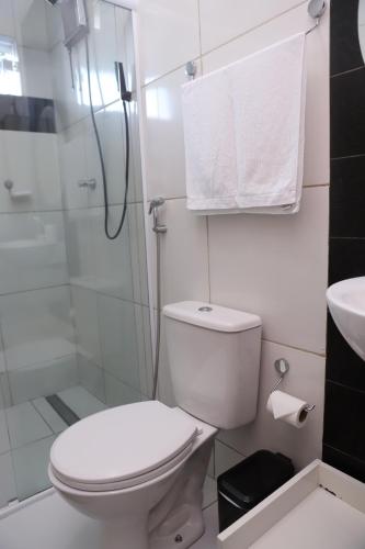 a white bathroom with a toilet and a shower at Edícula Próxima a Praias! in São Luís