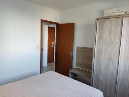 a bedroom with a bed and a wooden closet at Riviera Park in Caldas Novas