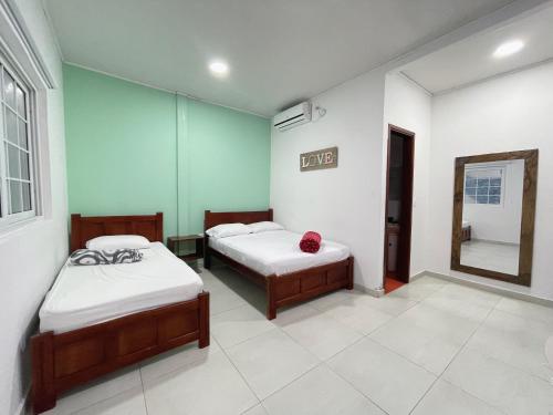 a room with two beds and a mirror in it at Apartahotel Caribe Diez in San Andrés