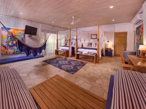 a bedroom with two beds and a hammock in it at Blue Apple Beach in Tierra Bomba