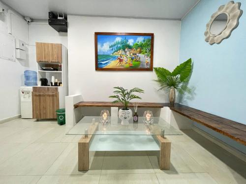 una sala de estar con una mesa y una pintura en la pared en Apartahotel Caribe Diez, en San Andrés