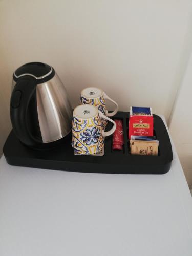 a black shelf with two mugs and a tea kettle at La Neviera in Struda