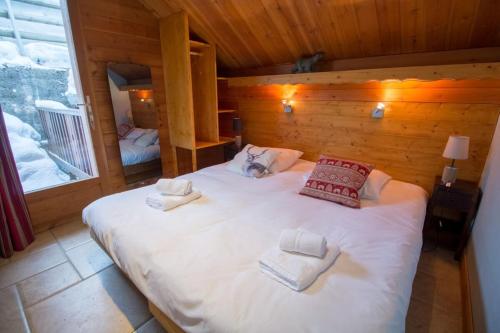 a bedroom with a large white bed in a cabin at Chalet Clearmount with Spa in Méribel