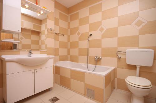 a bathroom with a toilet and a sink and a tub at Apartments with a parking space Gradac, Makarska - 6820 in Gradac