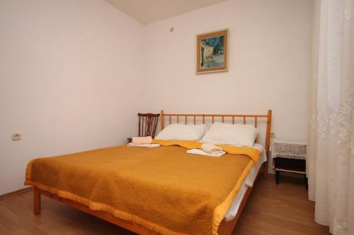 a bedroom with a bed with an orange blanket at Apartments with a parking space Gradac, Makarska - 6820 in Gradac