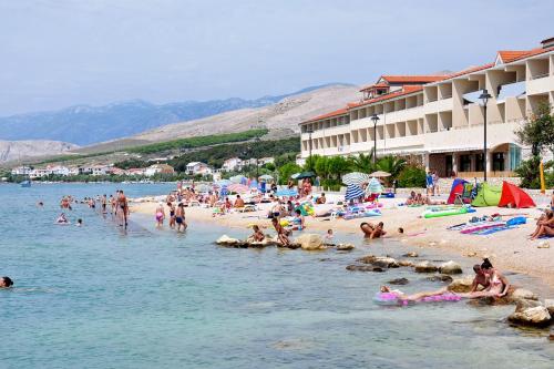 a group of people on a beach in the water at Double Room Pag 6311b in Pag