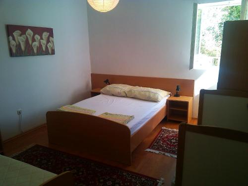 a small bedroom with a bed and a window at Apartments with a parking space Sveti Petar, Biograd - 3251 in Sveti Filip i Jakov