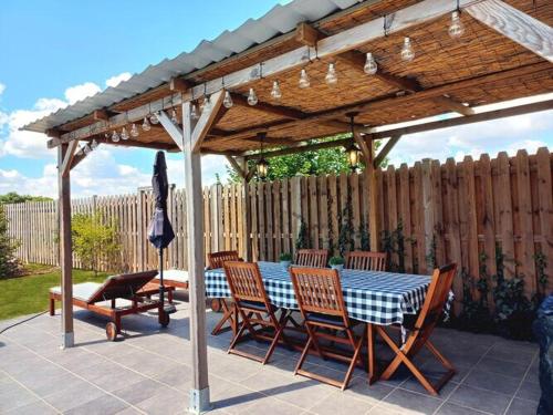 einen Tisch und Stühle unter einer hölzernen Pergola in der Unterkunft Beautiful villa in central France in La Chapelle-Blanche-Saint-Martin