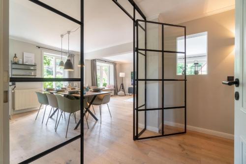 a glass partition in a dining room with a table at Fietje in Südstrand
