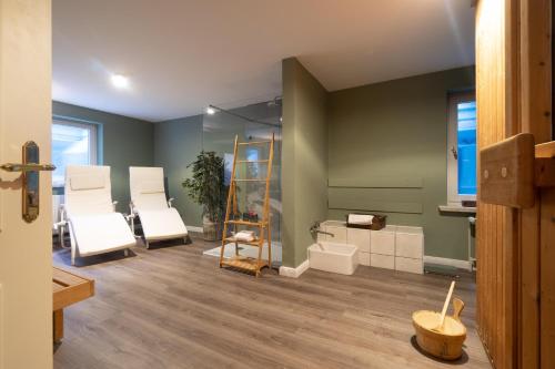 a room with white chairs and a mirror at Fietje in Südstrand